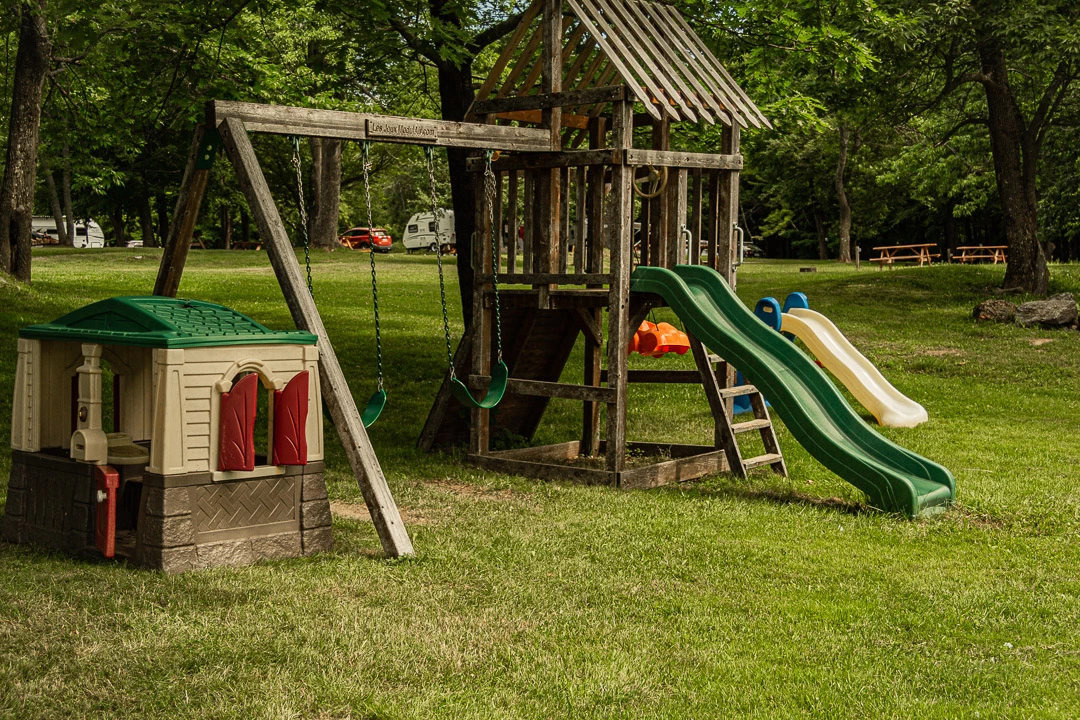 Aire de jeux pour enfants avec toboggans et balançoires.