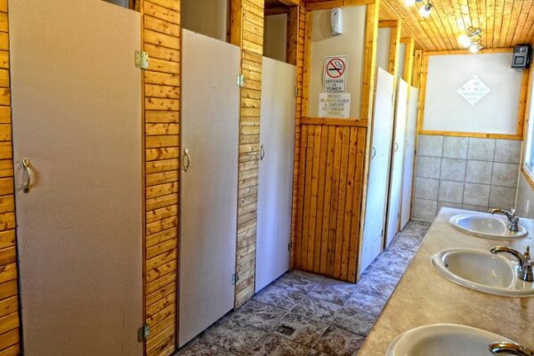 Intérieur de toilettes publiques en bois et carrelage.
