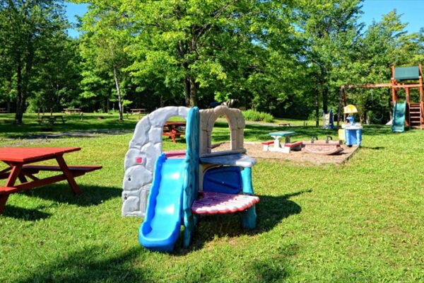 Aire de jeux pour enfants avec toboggan et table.