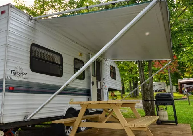 Caravane avec auvent et table de pique-nique.