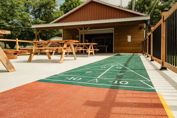 Terrasse avec tables de pique-nique et jeu de shuffleboard.